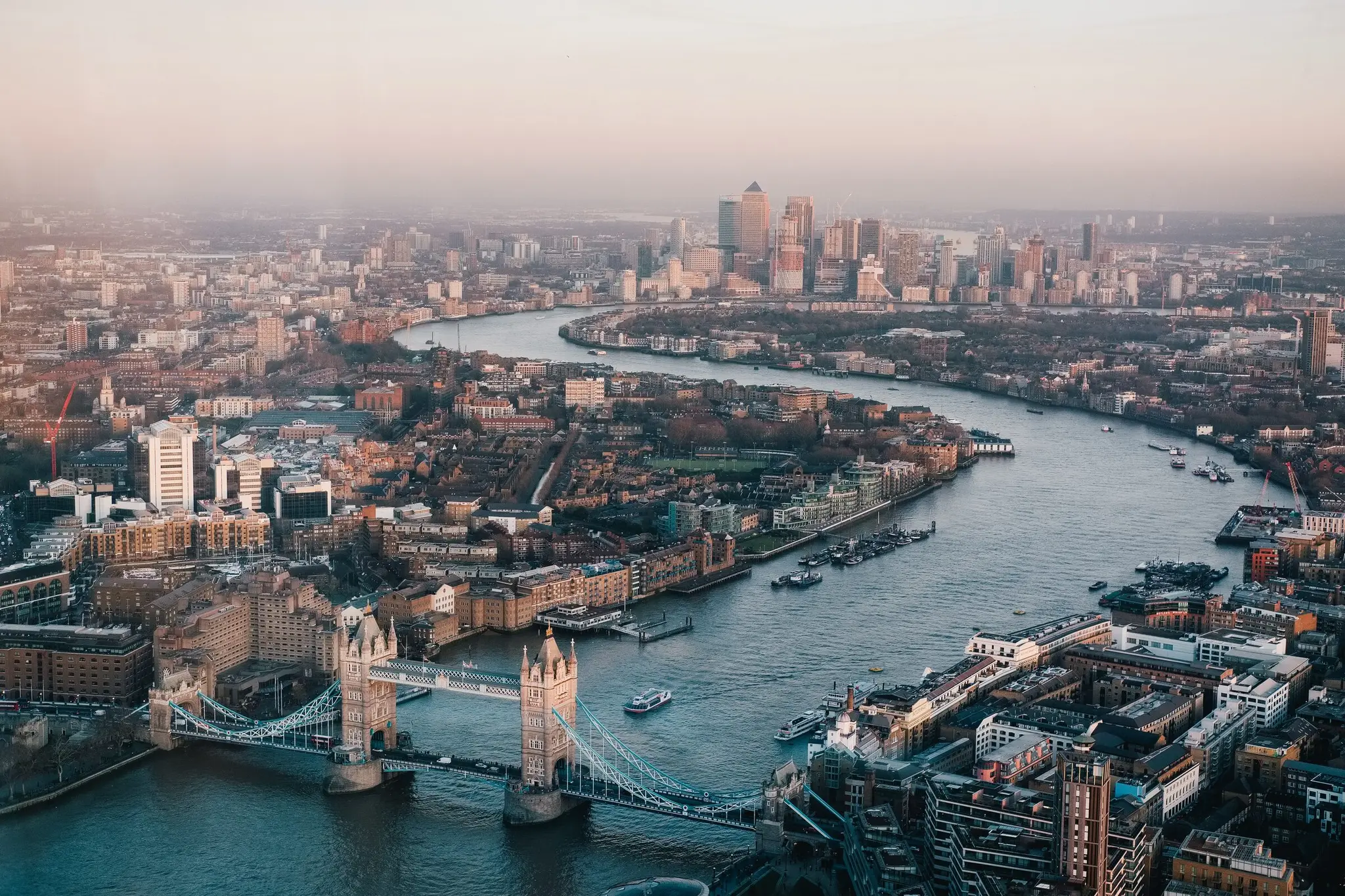 Tower Bridge and the River Thames winding through London, viewed from above